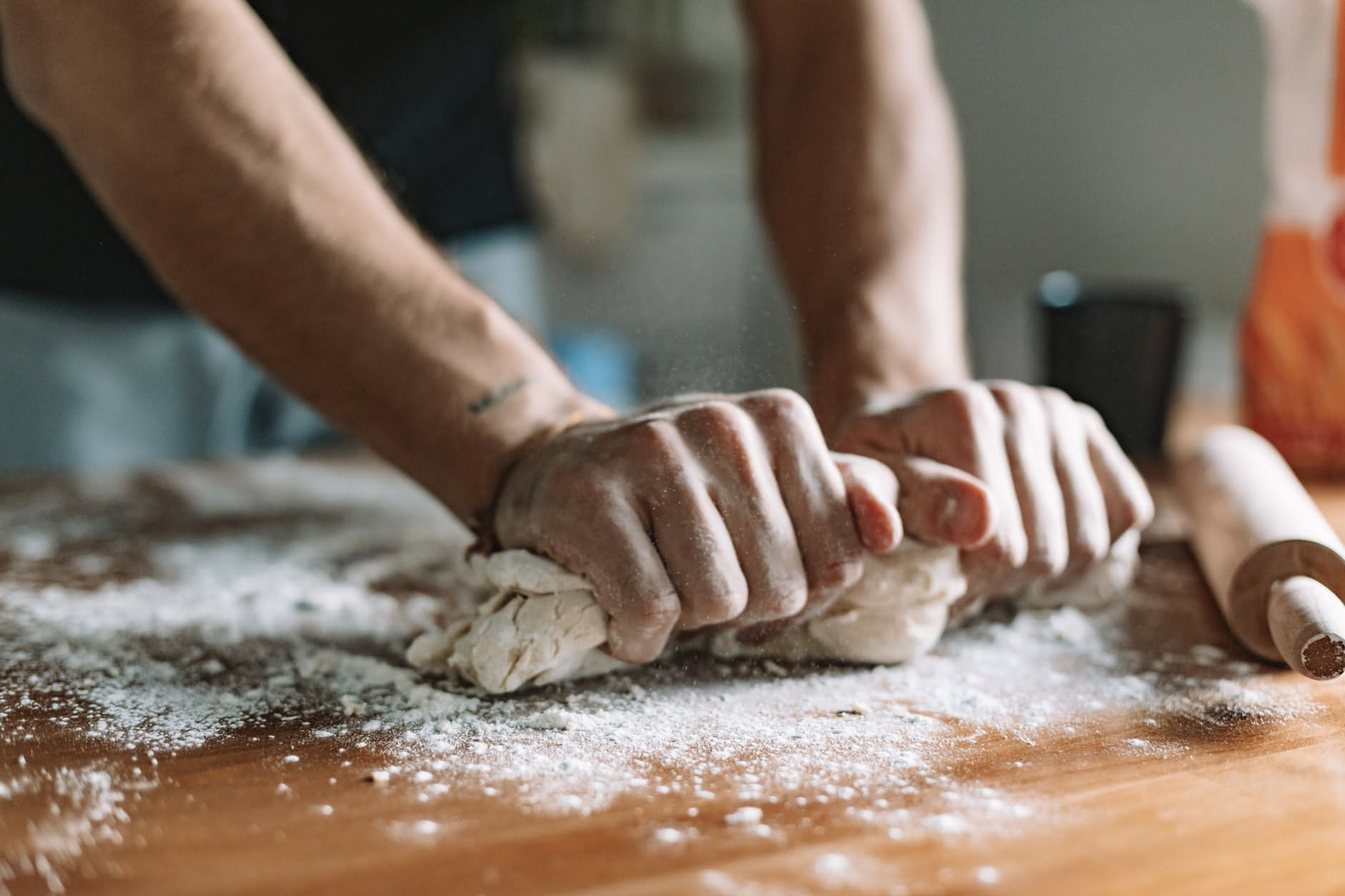 Una pallina di impasto pizza su un piano di marmo grigio, tesa e rigida, che non si estende, con sfondo neutro e luce naturale