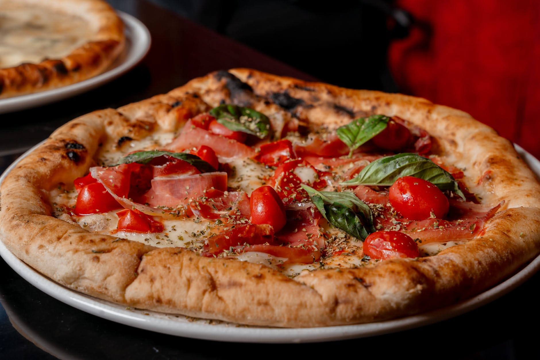 Pizza romana quadrata sottile e dorata con cornicione croccante, margherita con mozzarella e basilico, tagliata in quadretti su carta bianca