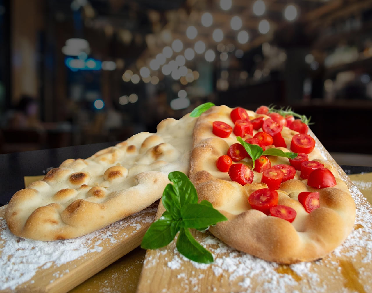 Pizza bianca napoletana con ricotta fresca, provolone affumicato e pepe nero appena tirato fuori dal forno a legna, con cornicione dorato e piega perfetta.