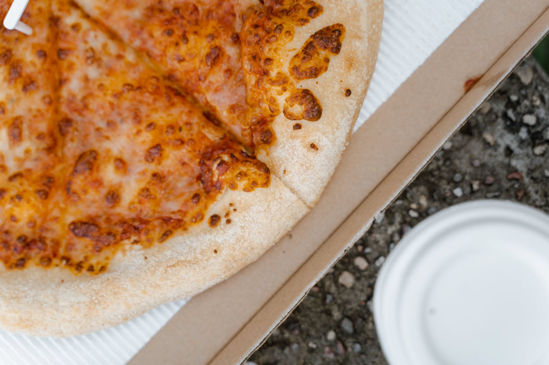Una fetta di pizza margherita su un piatto dentro un forno a microonde con il display che mostra il tempo di riscaldamento