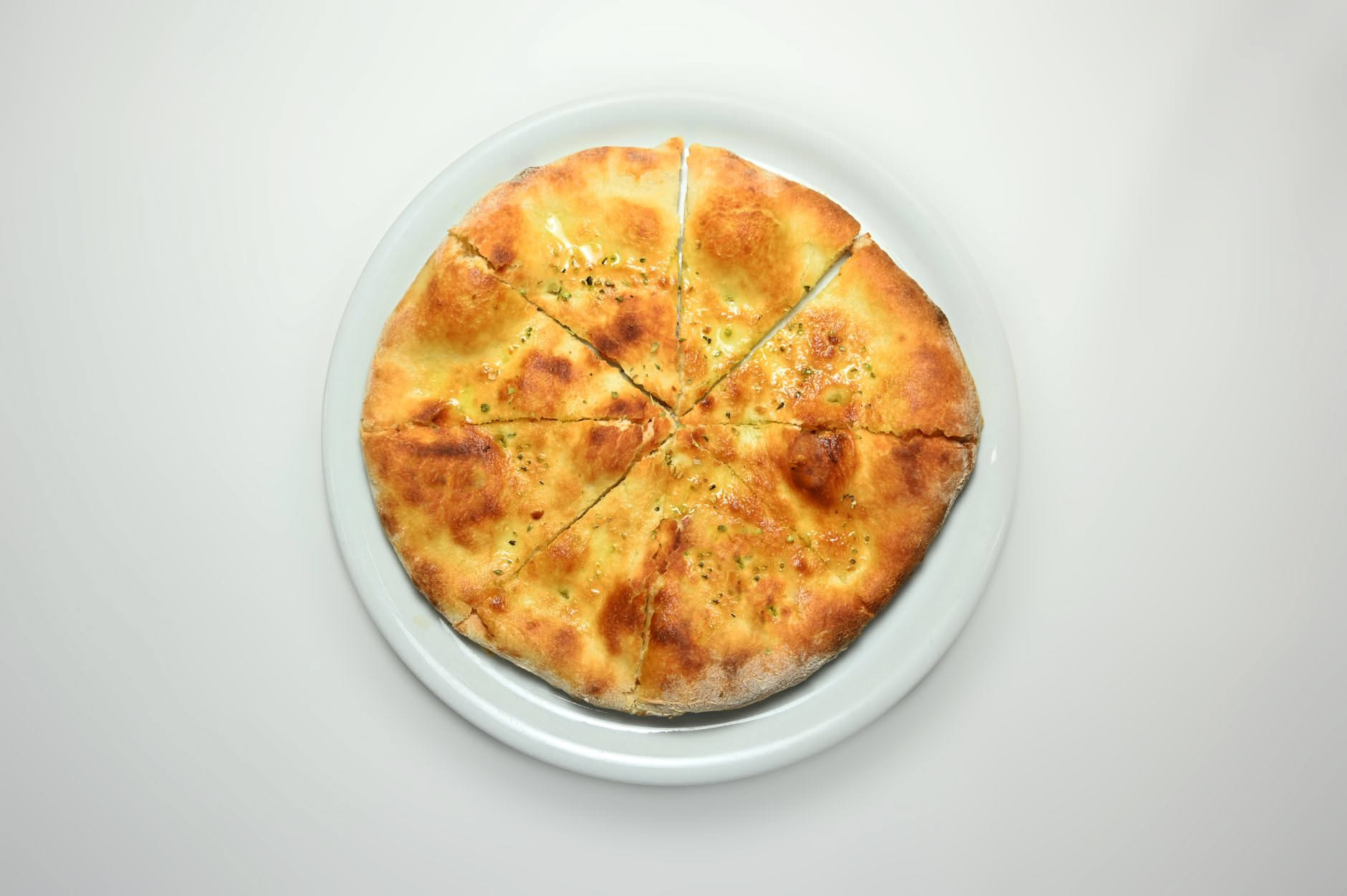 Fetta di scrocchiarella romana appena sfornata con cornicione dorato e croccante, vapore ancora visibile, su carta bianca