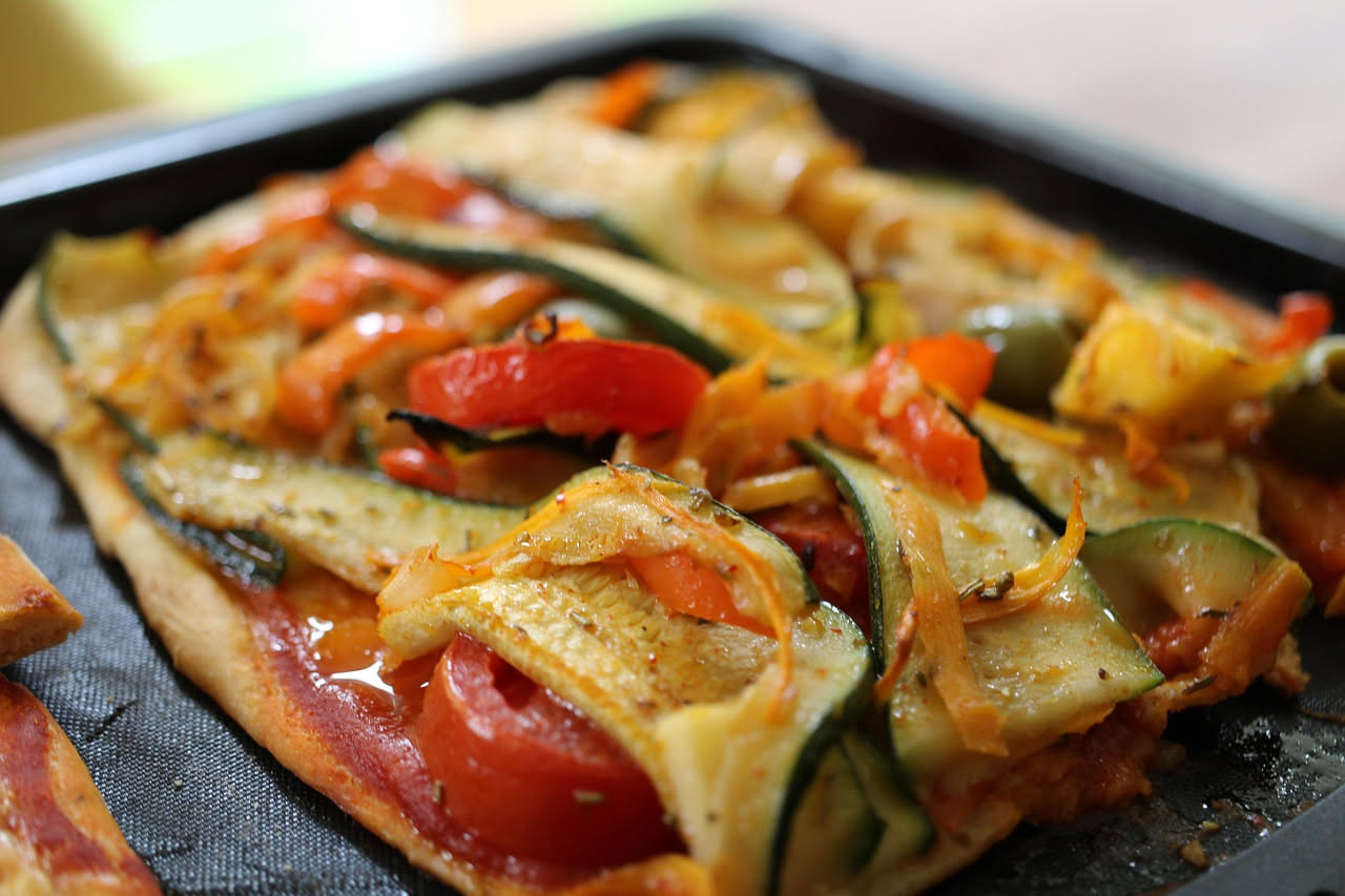 Impasto per pizza in teglia bagnato e umido in una vaschetta di plastica trasparente, con bolle di fermentazione visibili in superficie