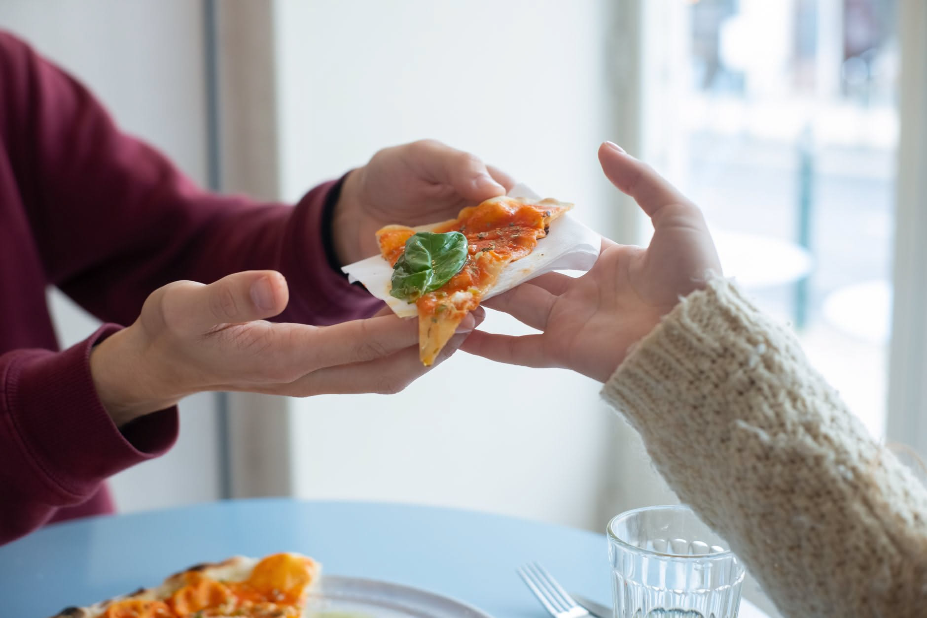 Fetta di pizza appena riscaldata in teglia metallica, cornicione dorato e croccante, formaggio fuso al centro su sfondo scuro