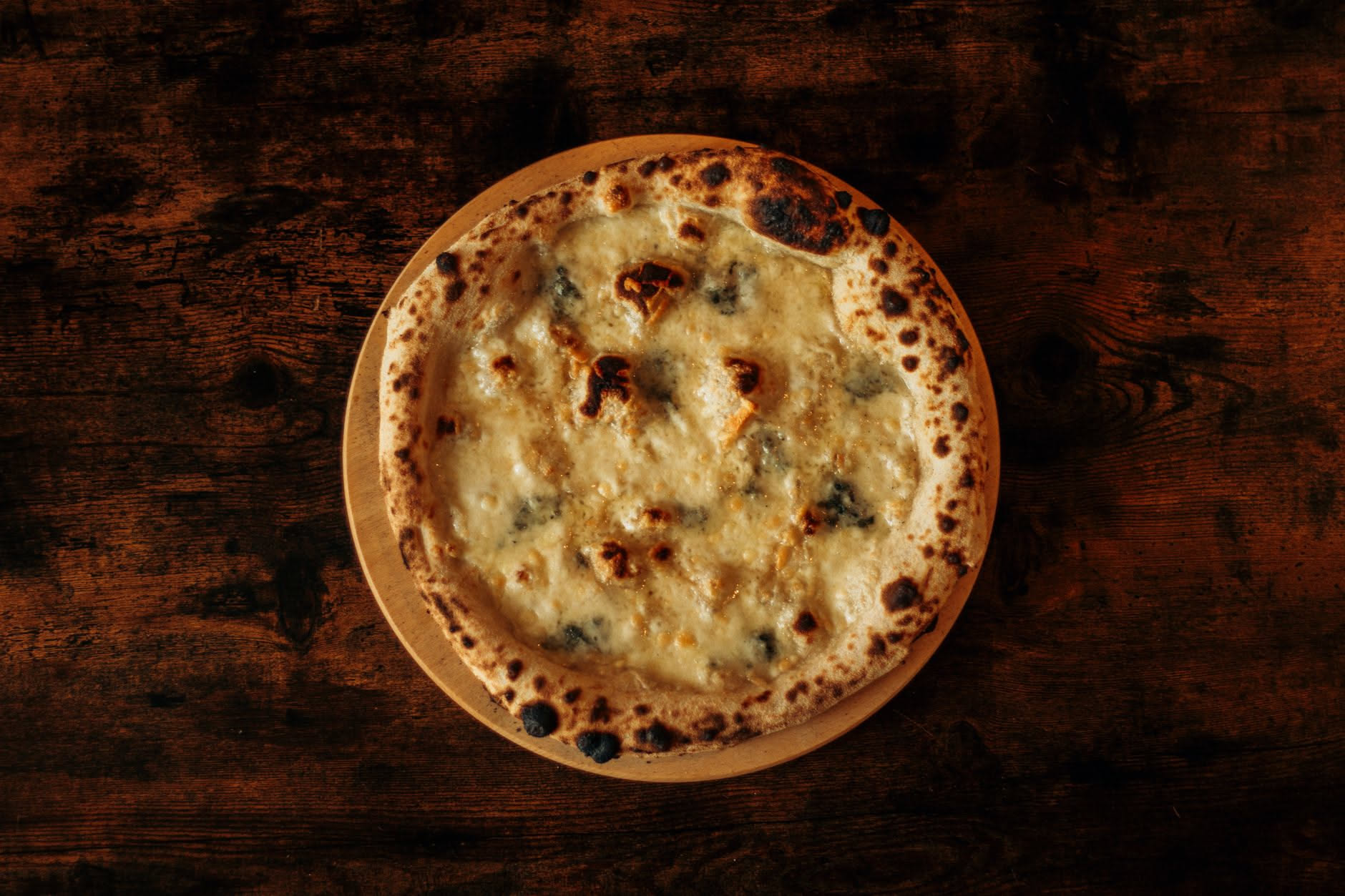 Pizza bianca con quattro formaggi fusi appena uscita dal forno